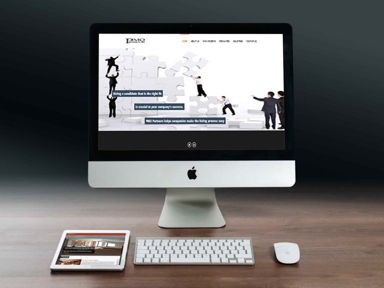 PMO Partners website with a puzzle-piece banner about hiring, on a desktop monitor with a tablet beside it