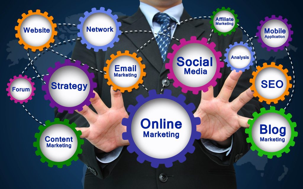 Businessman with open hands among colorful gears labeled SEO, Social Media, Blog and Email