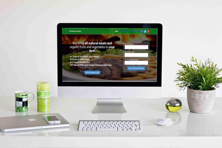 Food delivery website, "We bring all-natural meats and organic fruits and vegetables to your door", on a desktop monitor