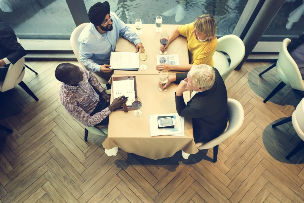 Overhead view of a team meeting around a table with laptops
