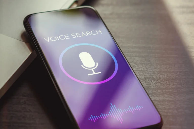 Phone showing a voice search screen with a microphone icon on a table