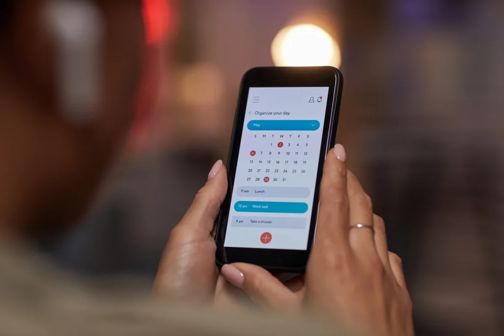 Hands holding a phone with a calendar app